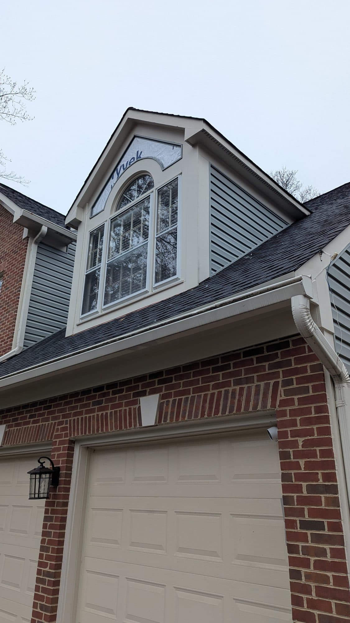 Finished gable dormer with new siding and a large arched window