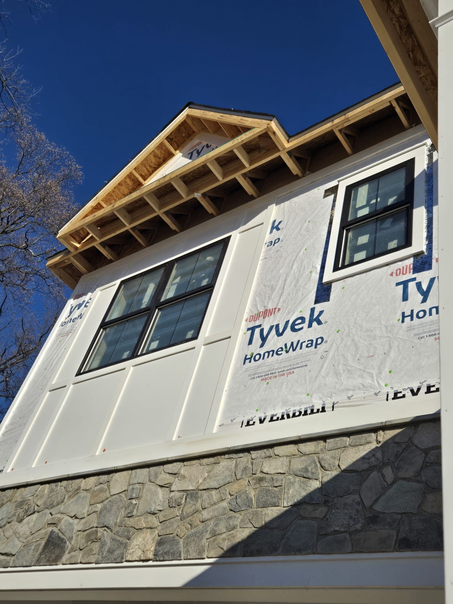 Home wrapped in Tyvek HomeWrap house wrap with a gabled dormer, prepped for siding installation